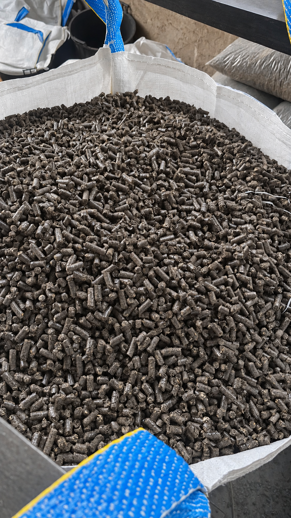 Ciemny pellet z łuski słonecznika wewnątrz otwartego big bagu — zbliżenie